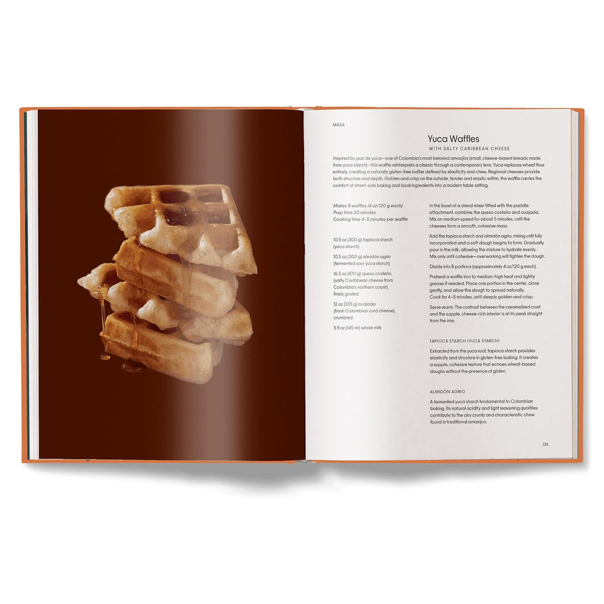 An open cookbook or recipe book spread showing a photo of stacked waffles on the left page and the recipe text for 'Yuca Waffles' on the right page, photographed on a clean white background.