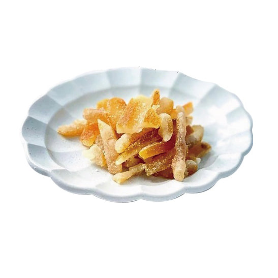 White plate with a pile of candied yuzu on a white background