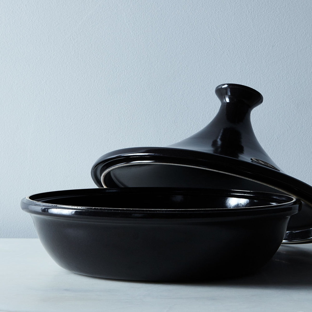 Black fusain ceramic tagine with a Emile Henry logo on a white background