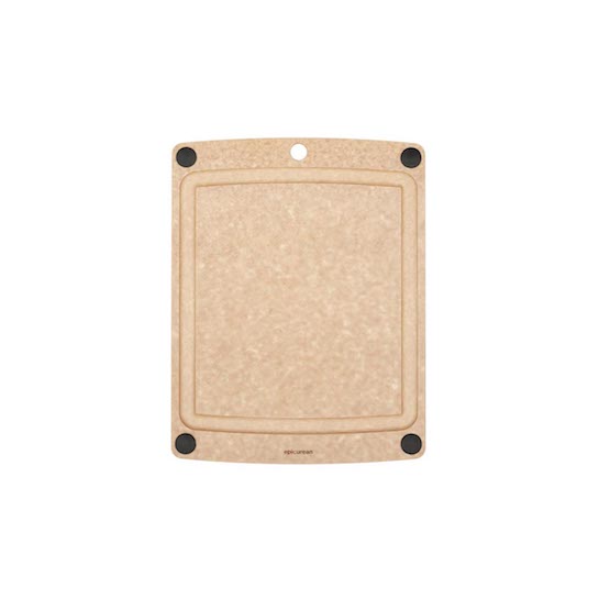Natural cutting board with black non-slip feet on a white background