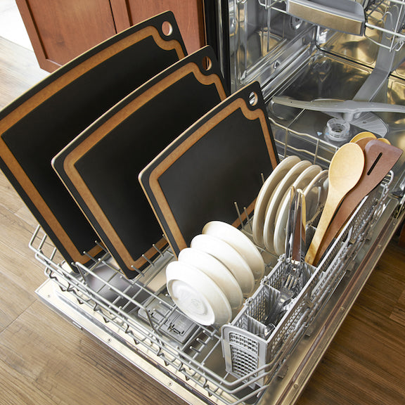 Open dishwasher with Epicurean gourmet cutting boards with cutlery and plates inside