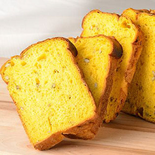 Slices of yellow Hokkaido pumpkin bread on a wooden surface