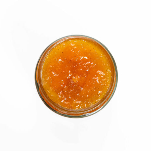 Jar of orange jam on a white background