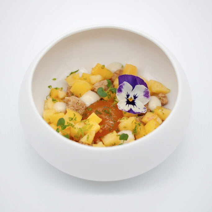 White bowl with a colorful salad on a white background