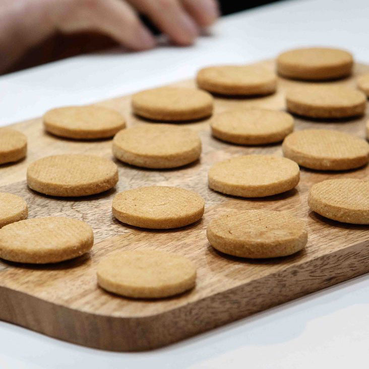 Biscuits on a wooden board with a hand reaching towards them