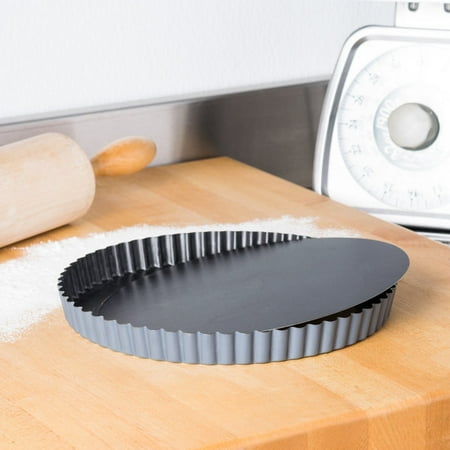Matfer fluted quiche pan on a wooden surface with flour and a rolling pin.