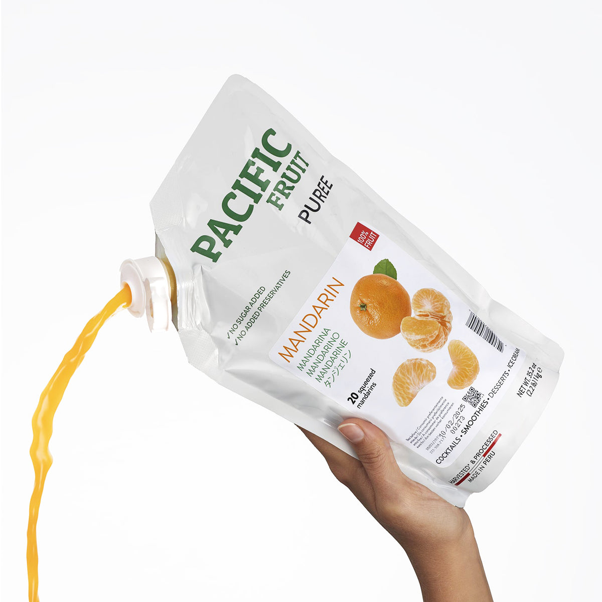 Hand holding a pouch of Pacific Fruit Mandarin Puree with mandarin oranges on the label.