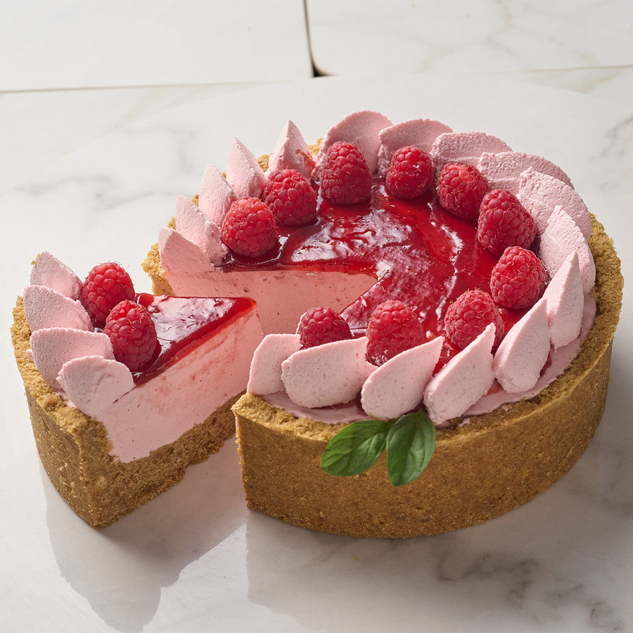 Pink strawberry cheesecake made using Pacific Fruit puree with a slice taken out on a marble surface