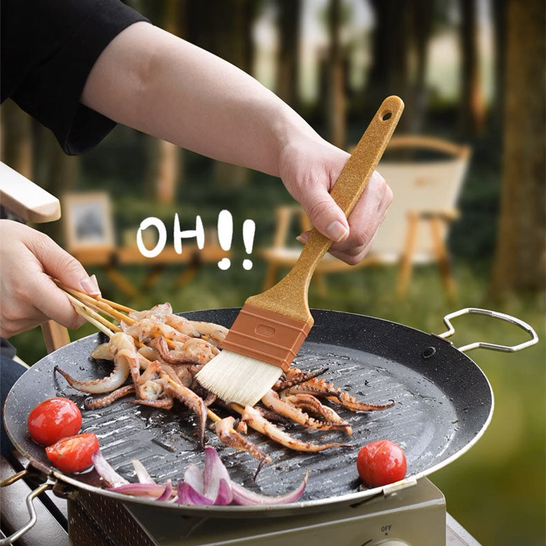Person grilling squid and tomatoes on a portable stove with a scenic background