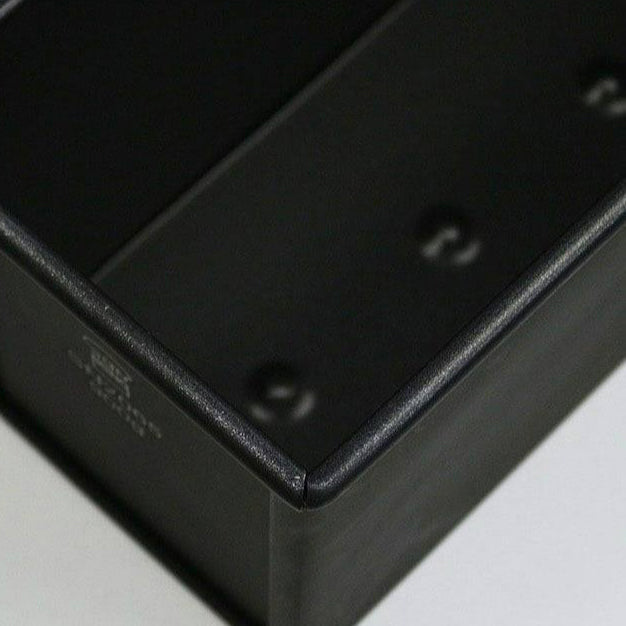 Close-up of a black interior of the Sanneng non-stick loaf pan on a white background