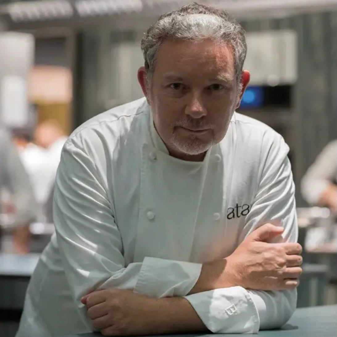 Chef wearing a white chef's coat in a kitchen setting