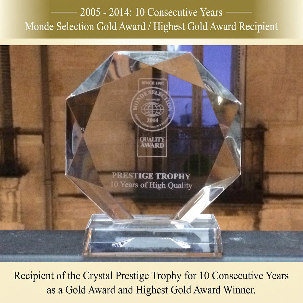 A faceted clear crystal award trophy on a transparent base, with engraved text including 'Crystal Prestige Trophy' and award recognition text above and below on a beige background.