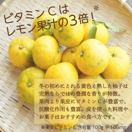 Basket of yuzus with Japanese text on a light wooden background