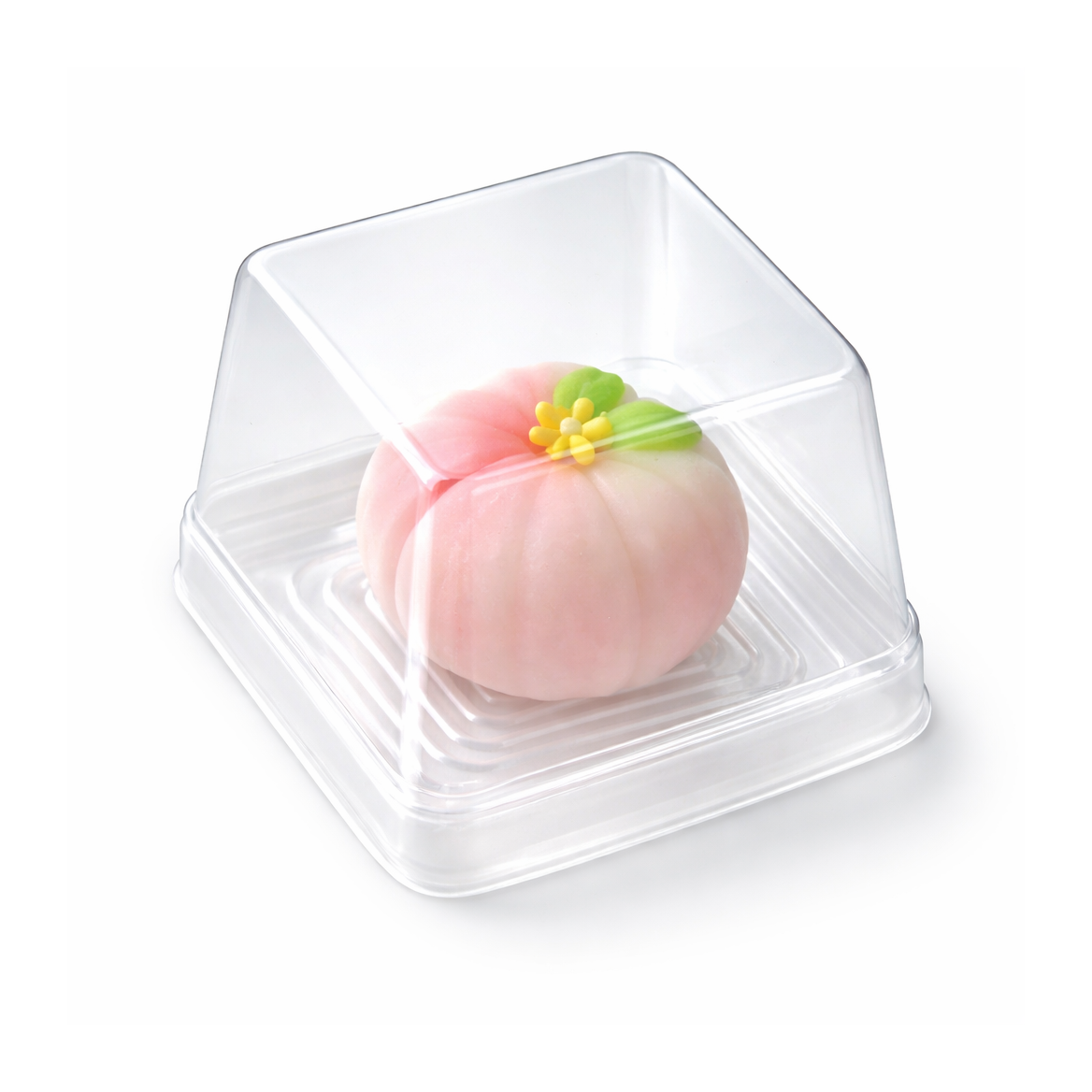 A pink wagashi dessert or pastry inside a clear square plastic container, photographed on a clean white background.