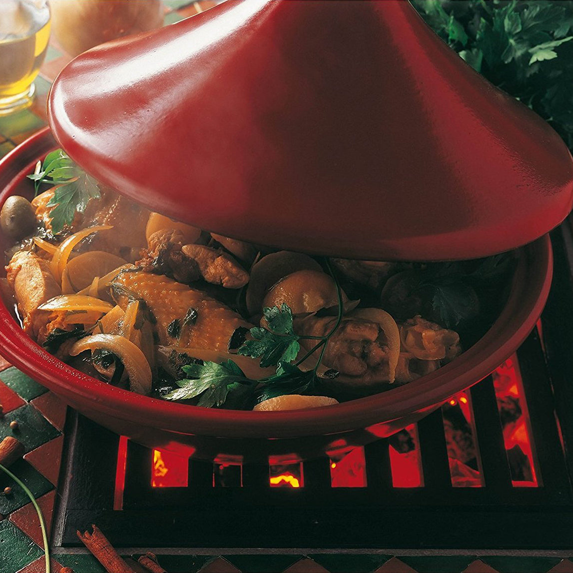 Red grand cru ceramic tagine with a Emile Henry logo on a white background