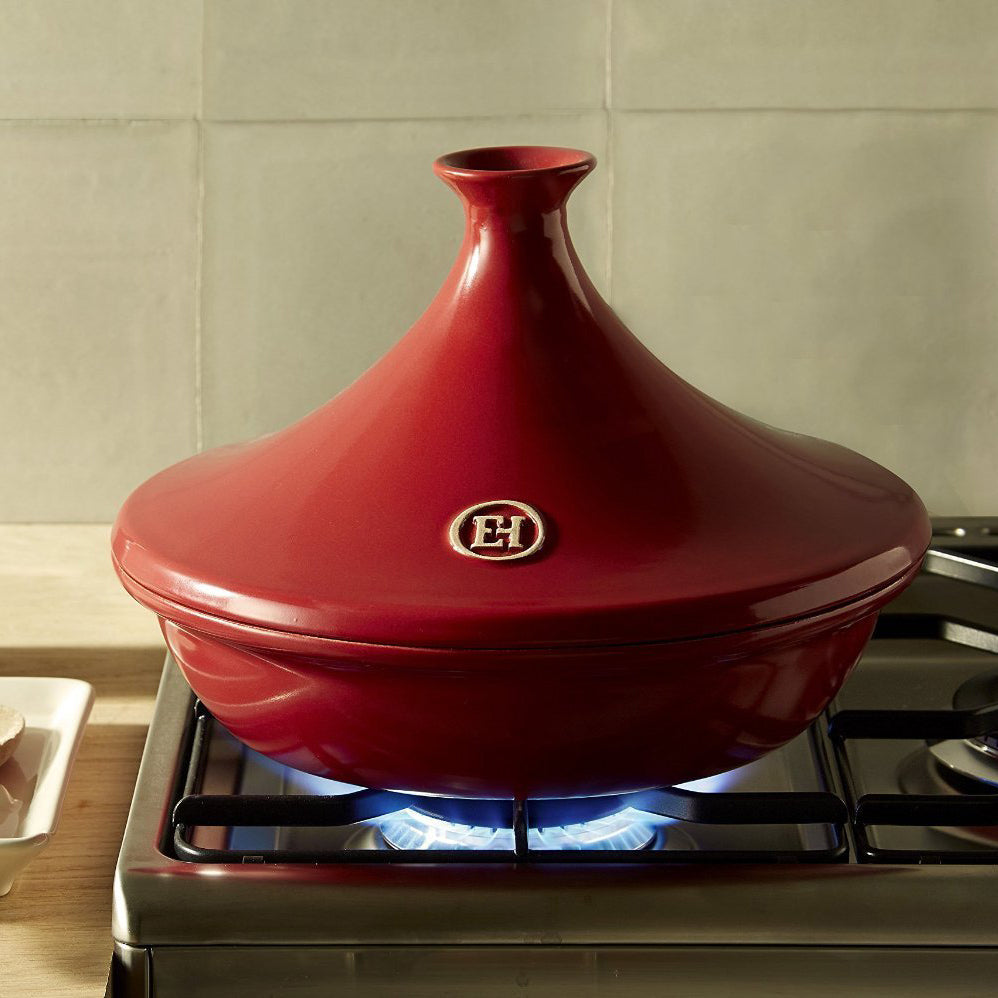 Red grand cru ceramic tagine with a Emile Henry logo on a white background