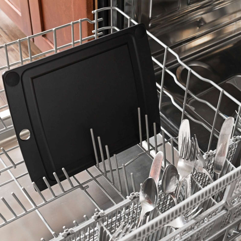 Dishwasher rack with black Epicurean all-in-one series cutting board with non slip feet and cutlery