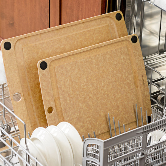 Two natural Epicurean all-in-one series cutting boards in a dishwasher rack with silverware.