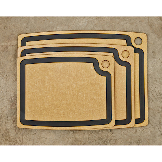 Set of three natural colour Epicurean Gourmet cutting boards with black juice groove on a beige background