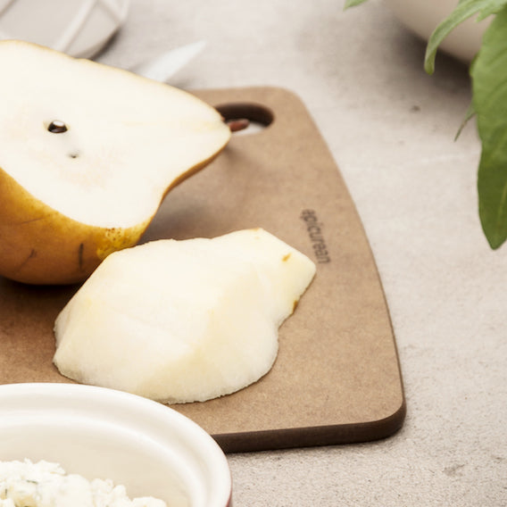 Pear on a Epicurean kitchen series cutting board with a bowl of rice in the background