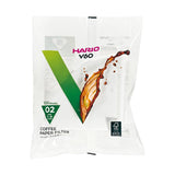 A package of 100 Hario V60 coffee paper filters, featuring a white and green design with a coffee splash graphic on a clean white background. VCF-02-100W