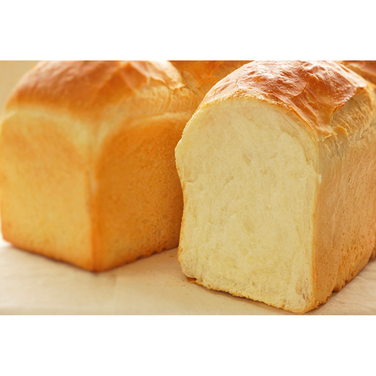 Loaf of bread with a slice cut off on a white background
