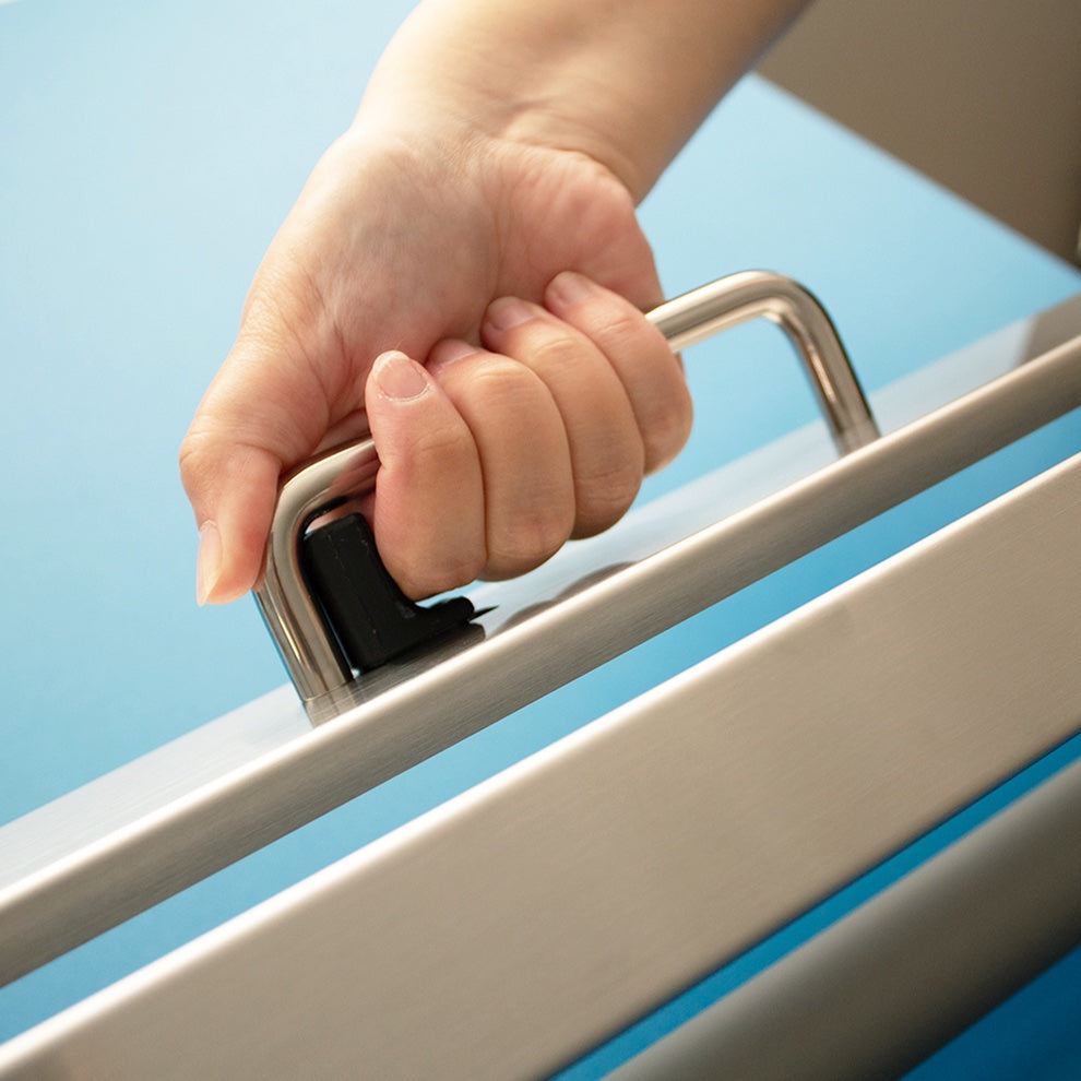 Hand holding a metal handle against a blue sky background
