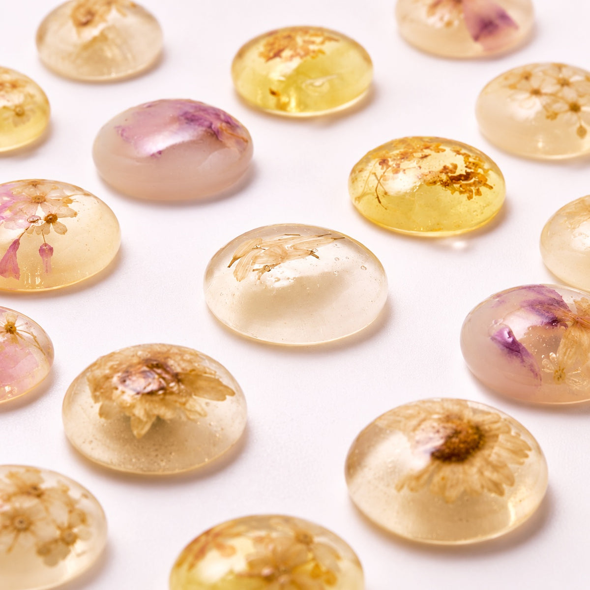 A close-up arrangement of round, translucent gel spheres containing dried flower petals, shown on a clean white background.