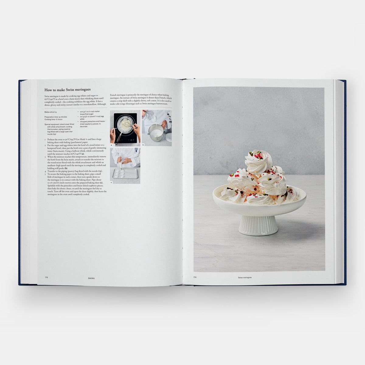 An open cookbook spread showing a recipe page on the left with text and small photos, and a large food photography page on the right featuring meringues on a white pedestal against a light gray background.