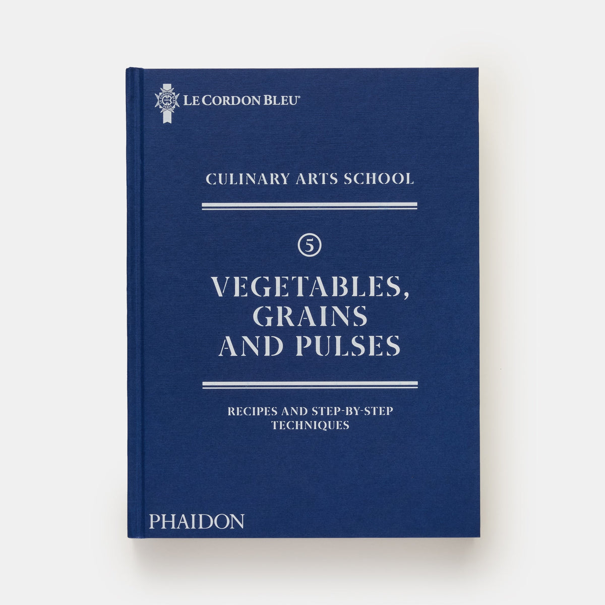 A hardcover book titled "Vegetables, Grains and Pulses" from Le Cordon Bleu Culinary Arts School, published by Phaidon. The book features a deep navy blue cover with white text and a white spine, shown against a clean, off-white background.