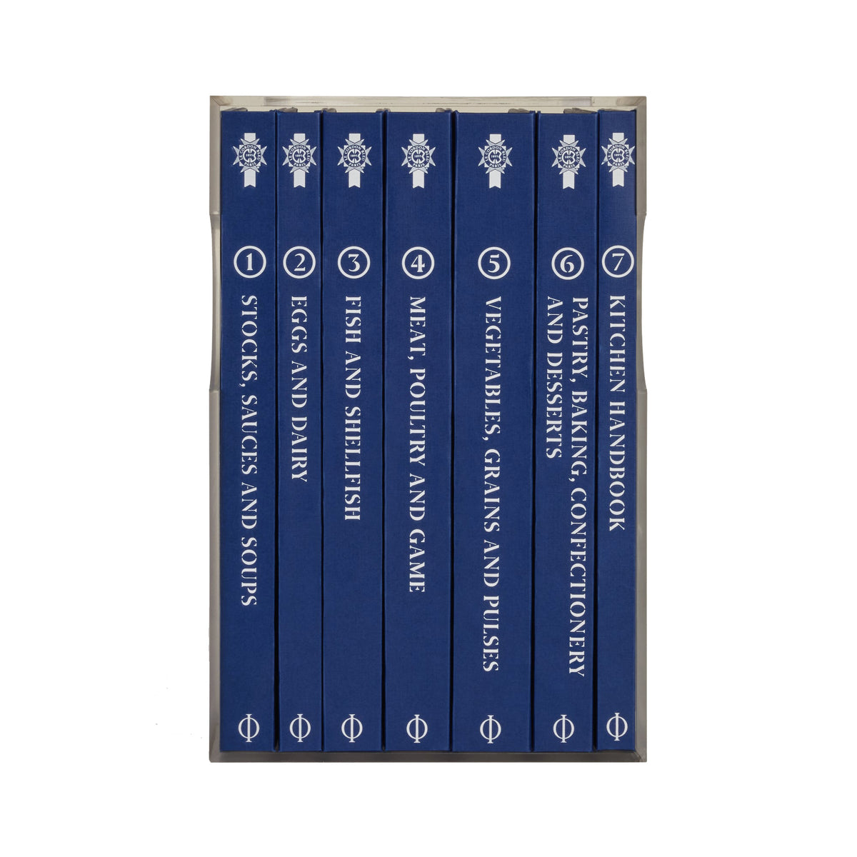 A boxed set of seven blue cookbooks standing upright in a clear plastic case against a white background. The spines are dark blue with white text and decorative crest logos, numbered 1 through 7.