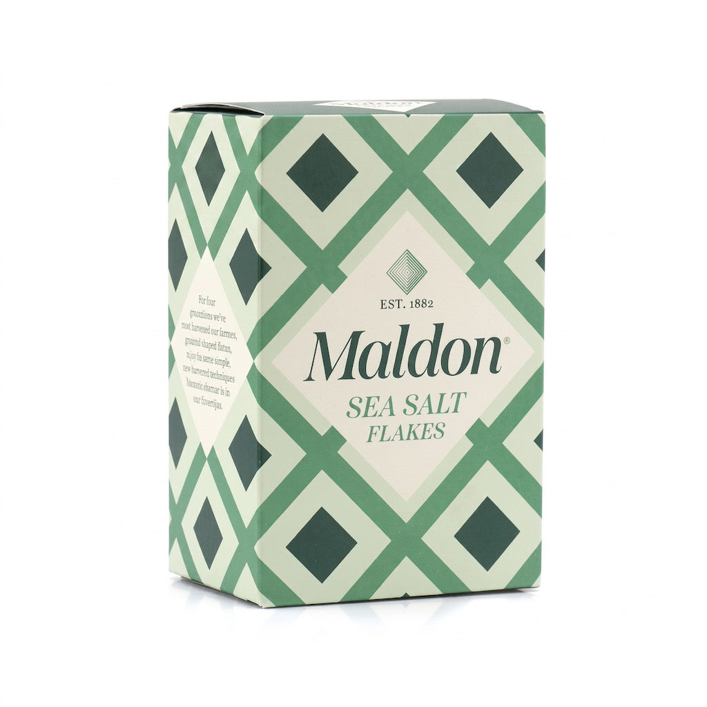 A box of Maldon Sea Salt Flakes featuring a green and cream geometric diamond pattern, with the brand name 'Maldon' printed prominently on the front.