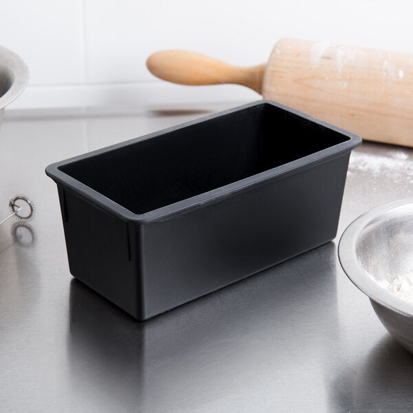 Black Matfer loaf pan on a kitchen counter with a rolling pin and bowl in the background