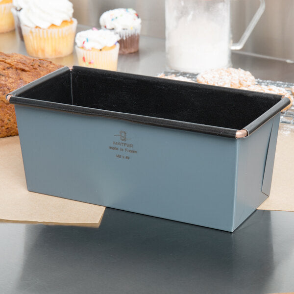 Grey Matfer loaf pan on a kitchen counter with baked goods in the background