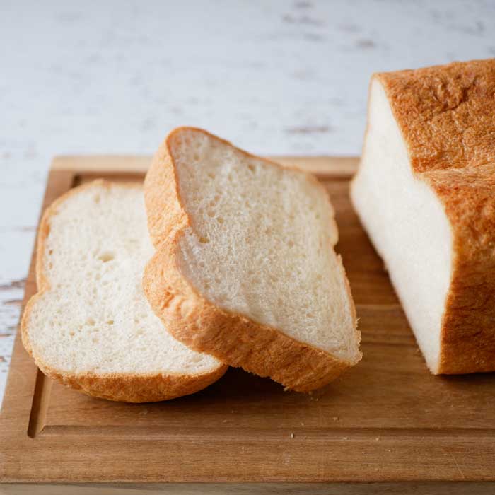 Sliced bread on a wooden cutting board with a marble background