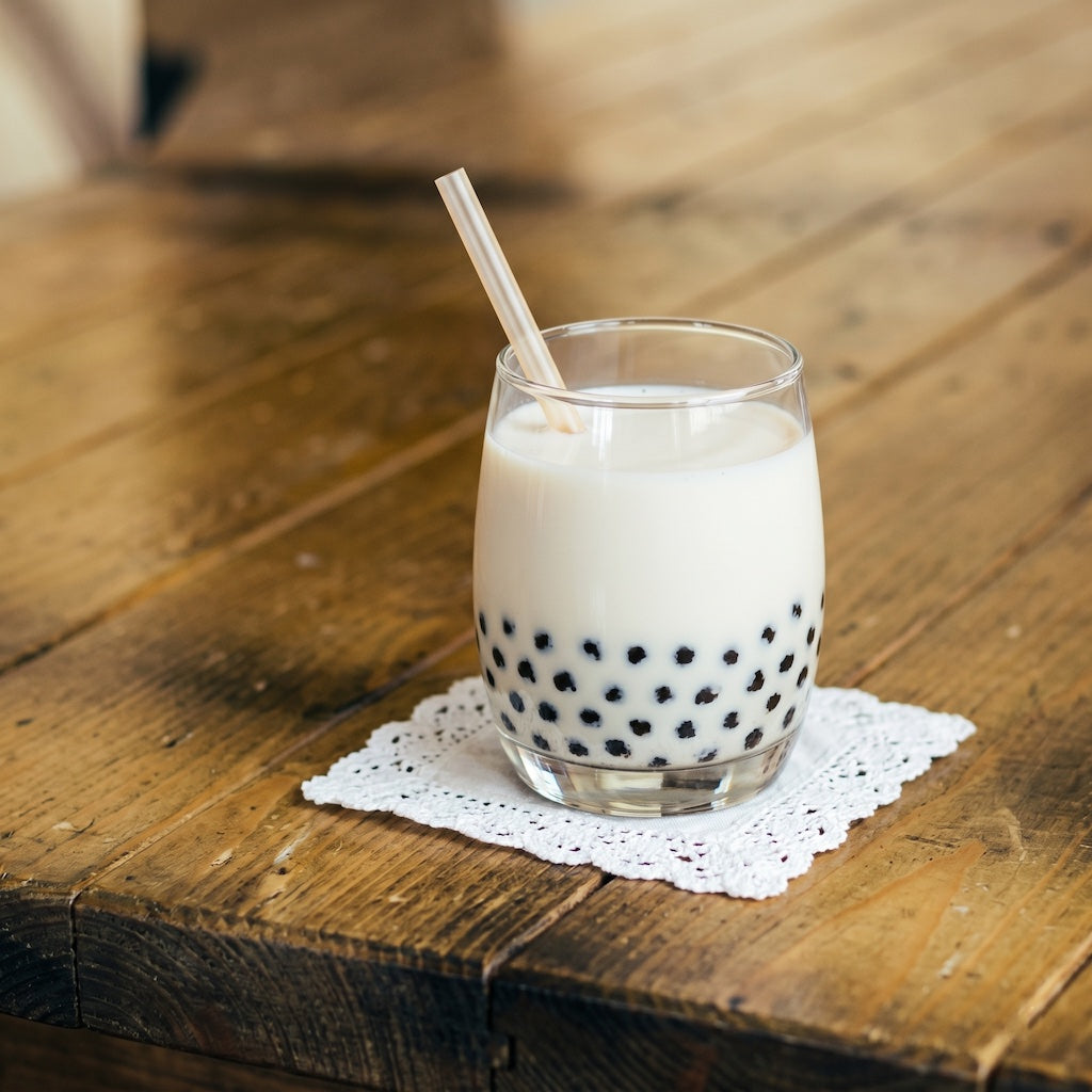 Glass of bubble tea with a straw on a wooden table