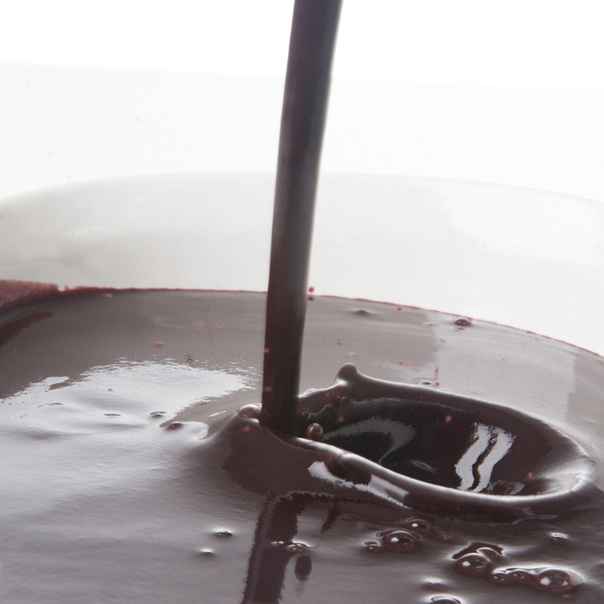 Pacific Fruit blueberry puree being poured into a glass with a blurred background