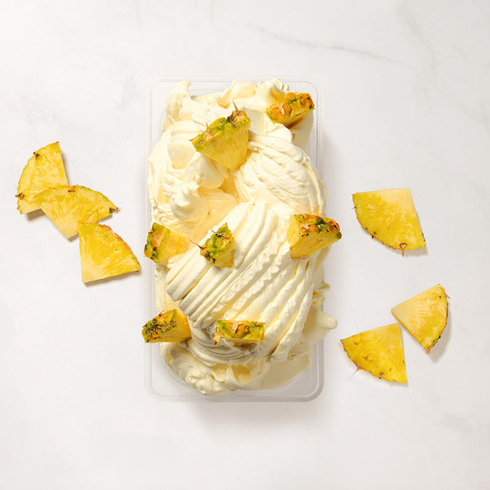 Pineapple gelato made using pineapple puree with pineapple pieces on a white background