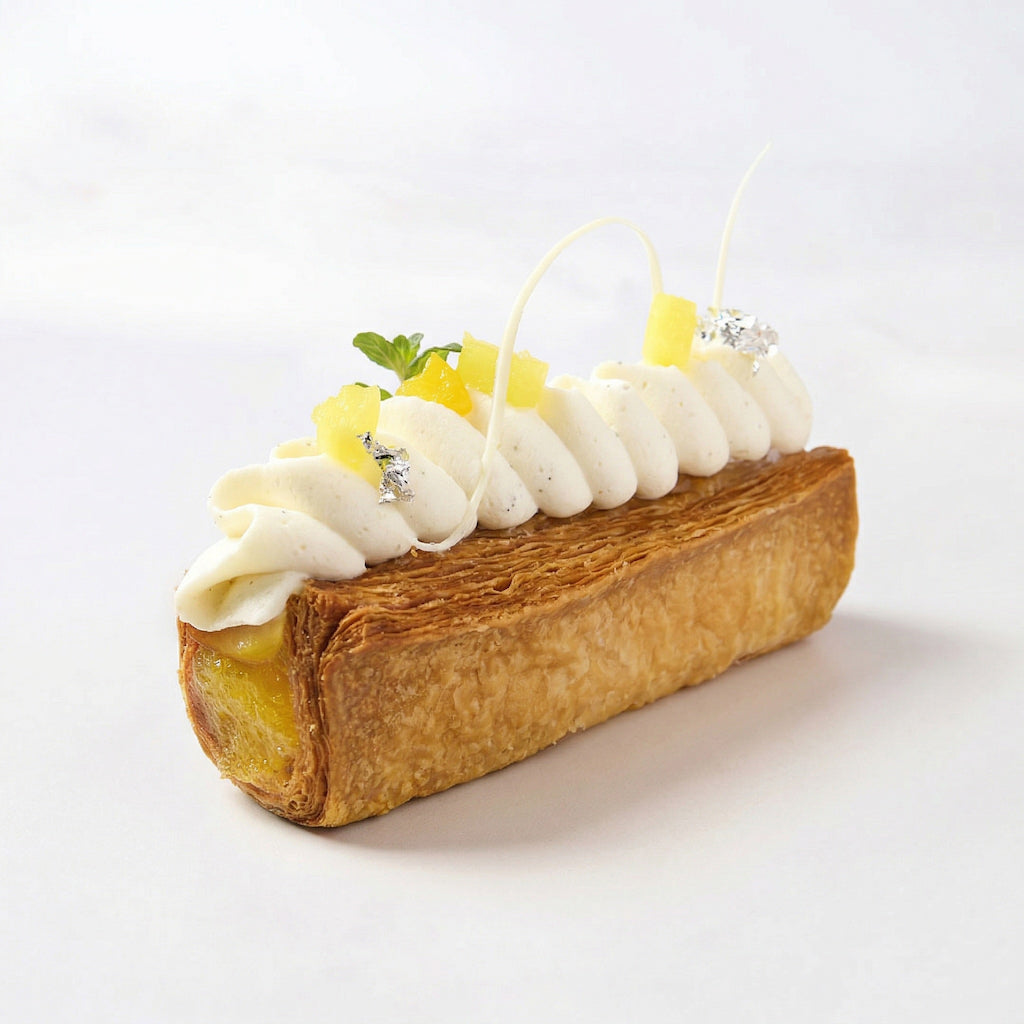 Delicate dessert with pastry, cream, and pineapple filling using puree on a white background
