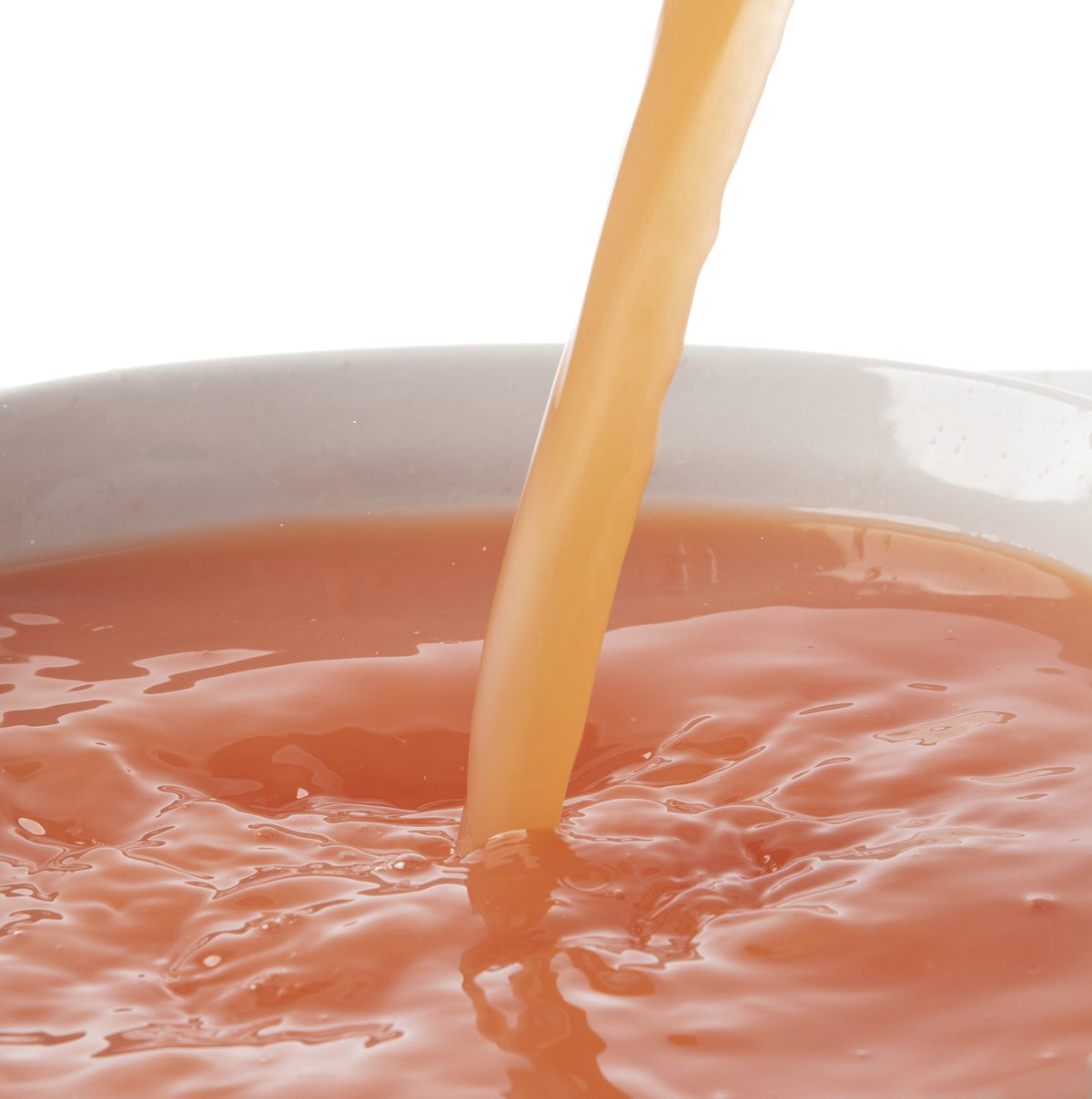 Pacific Fruit grapefruit puree juice being poured into a white bowl on a white background