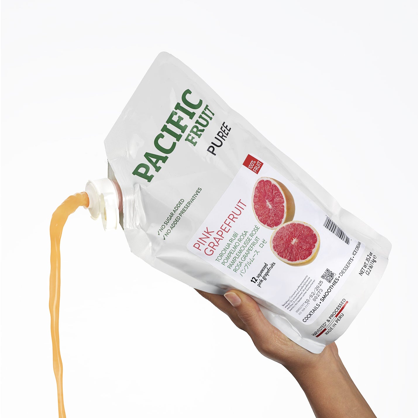 Hand holding a container of Pacific Fruit Shelf Stable Pink Grapefruit Puree with visible label.