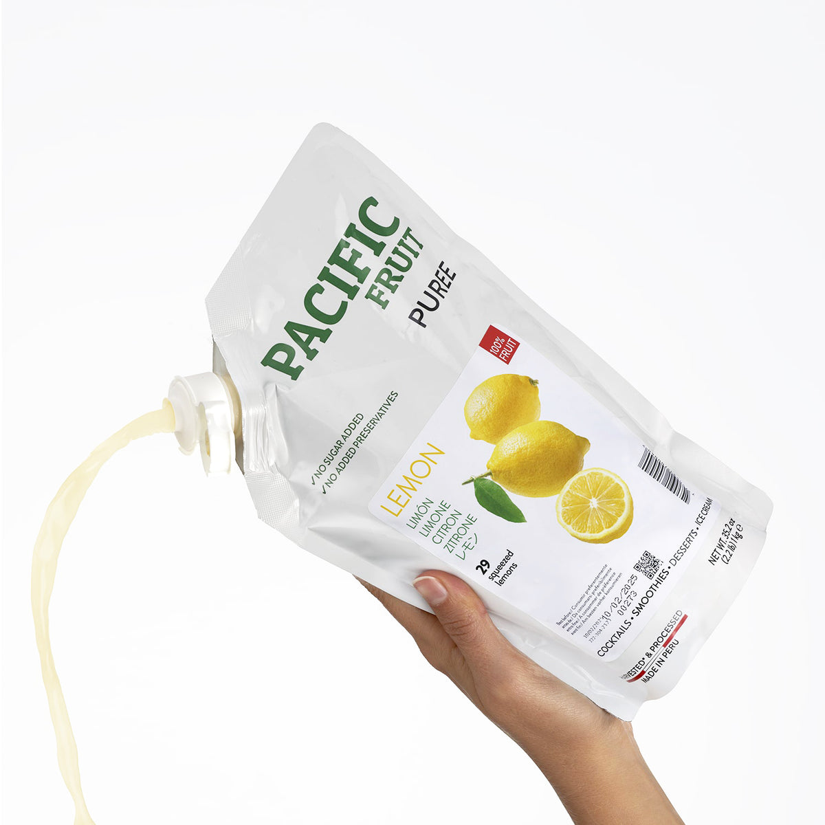 Hand holding a Pacific Fruit Puree lemon pouch on a white background
