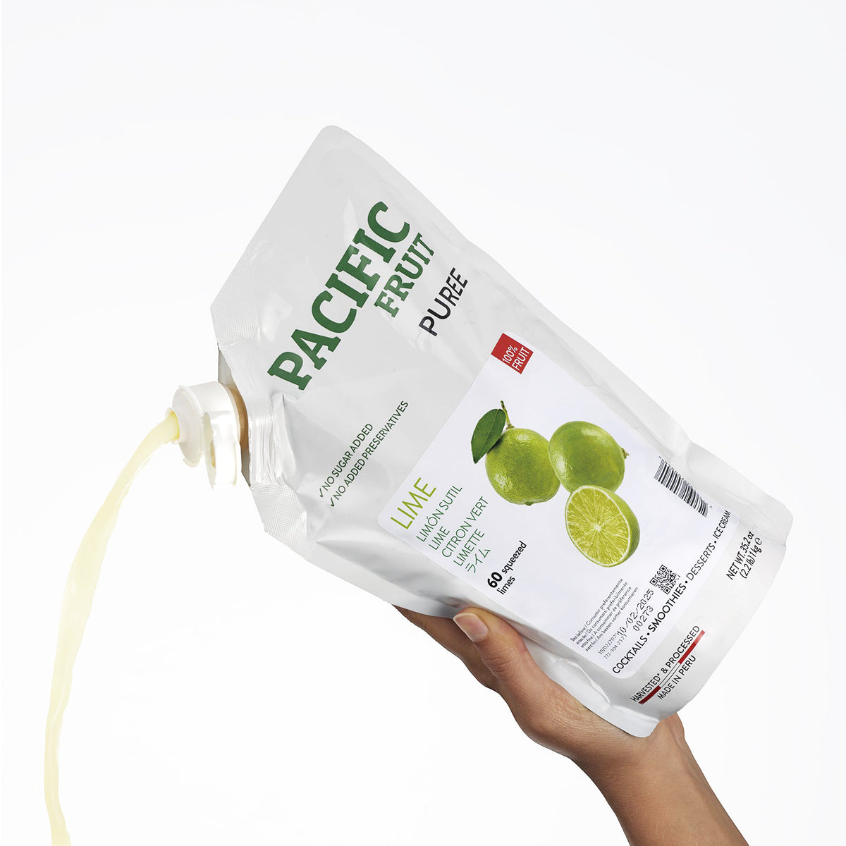 Hand holding a Pacific Fruit Puree Lime package on a white background