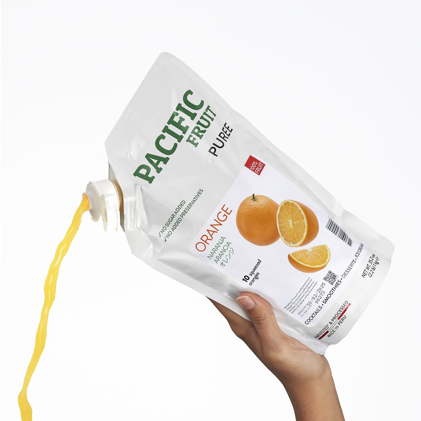 Hand holding a bag of Pacific Fruit Orange Puree on a white background.