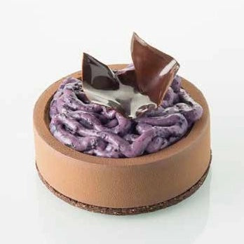 A round chocolate mousse cake with a smooth brown chocolate shell, purple whipped cream filling, and glossy chocolate shards on top, set against a clean white background.
