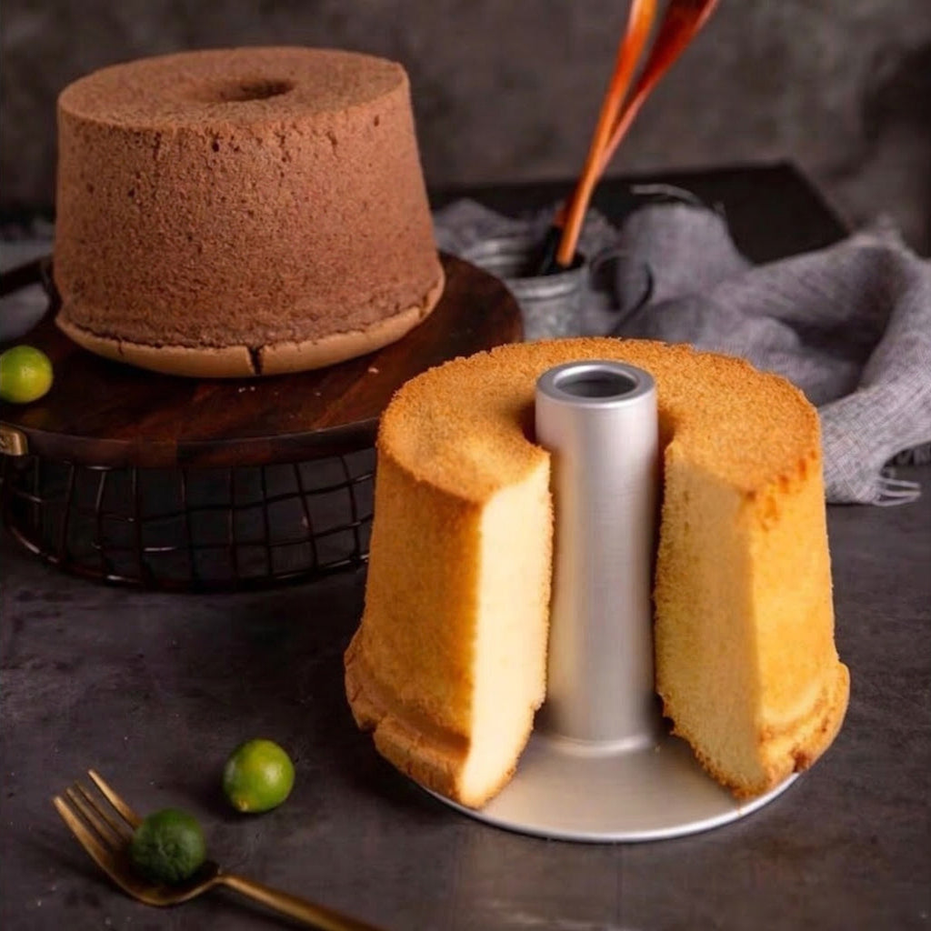 Two angel chiffon cakes on stands with a dark background
