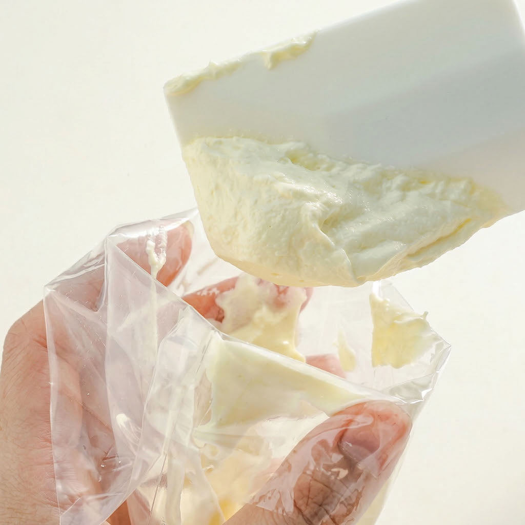 Cleaning a Sanneng white heat-resistant silicone spatula with a piping bag on a white background