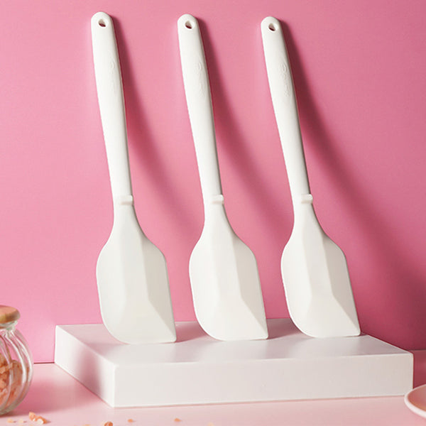 Three Sanneng white heat-resistant silicone spatulas on a pink background
