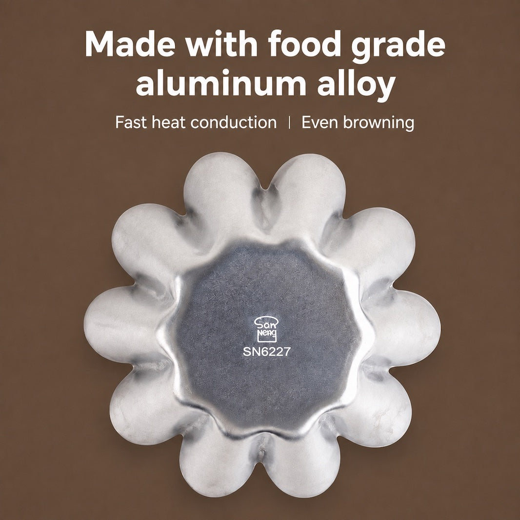 A flower-shaped aluminum baking pan with a silver metallic finish, shown from above on a brown background with white text that reads 'Made with food grade aluminum alloy' and 'Fast heat conduction | Even browning'.