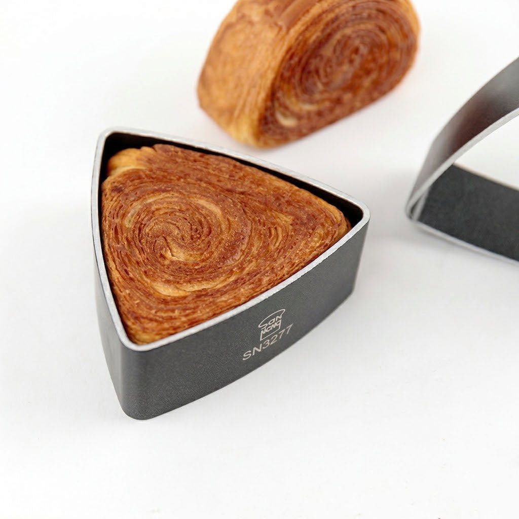Triangular croissant in a Sanneng non-stick ring mould on a white background